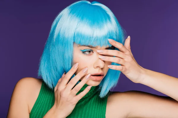 Chica de moda posando en peluca azul, aislado en púrpura - foto de stock