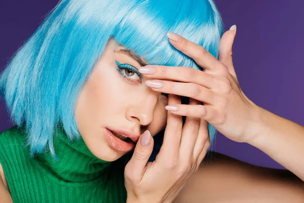 Menina bonita com maquiagem azul e peruca mostrando unhas com manicure, isolado em roxo — Fotografia de Stock
