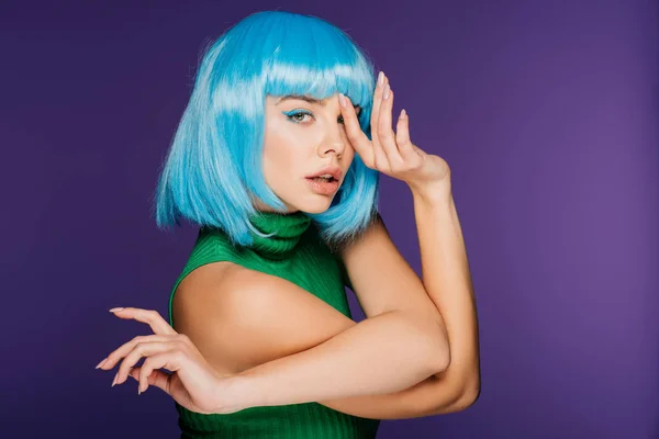 Bella ragazza alla moda gesticolando e posa in parrucca blu, isolato su viola — Foto stock