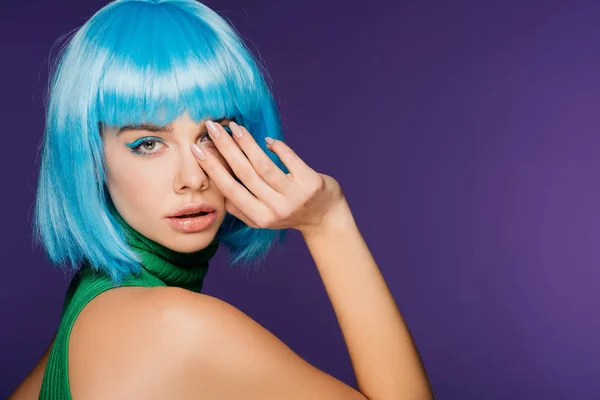 Menina elegante atraente posando em peruca azul, isolado em roxo — Fotografia de Stock