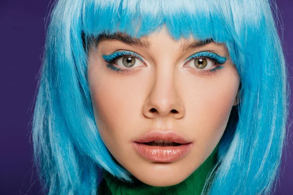 Menina atraente com maquiagem azul posando em peruca azul, isolado em roxo — Fotografia de Stock