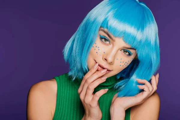 Atractiva chica de moda con peluca azul y estrellas en la cara, aislado en púrpura - foto de stock