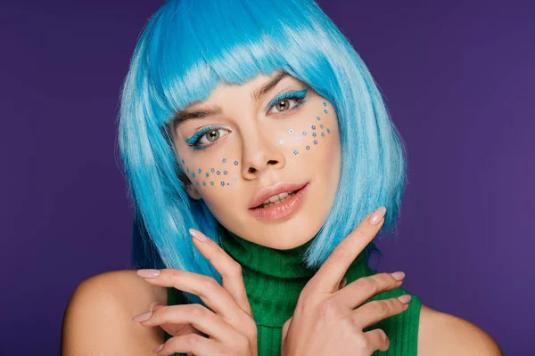 Atractiva chica glamour con peluca azul y estrellas en la cara, aislado en púrpura - foto de stock