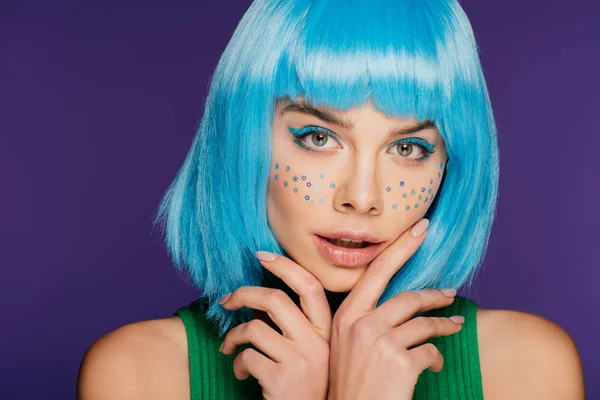 Glamour jovem com peruca azul e estrelas no rosto, isolado em roxo — Fotografia de Stock