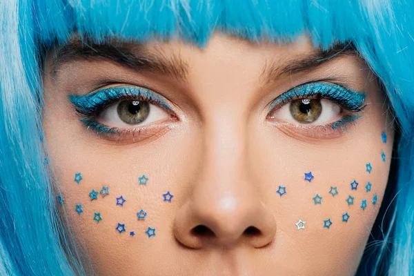 Close up de menina elegante com peruca azul, maquiagem e estrelas no rosto, isolado em roxo — Fotografia de Stock