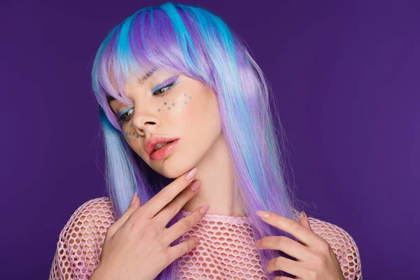 Красива дівчина позує у фіолетовій перуці з зірками на обличчі, ізольована на фіолетовому — стокове фото