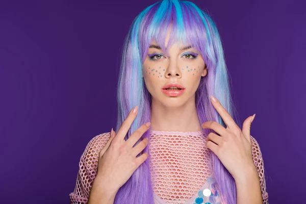 Attractive girl posing in violet wig with stars on face, isolated on purple — Stock Photo