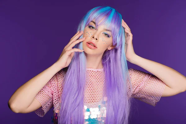 Modelo atractivo posando en peluca violeta con estrellas en la cara, aislado en púrpura - foto de stock