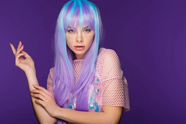 Красивая стильная девушка позирует в фиолетовом парике со звездами на лице, изолированные на фиолетовый — стоковое фото
