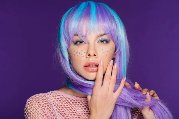 Beautiful sensual girl posing in violet wig with stars on face, isolated on purple — Stock Photo