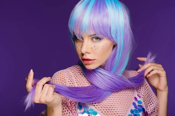 Modelo atractivo elegante posando en peluca violeta con estrellas en la cara, aislado en púrpura - foto de stock