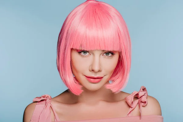 Fashionable smiling young woman posing in pink wig isolated on blue — Stock Photo