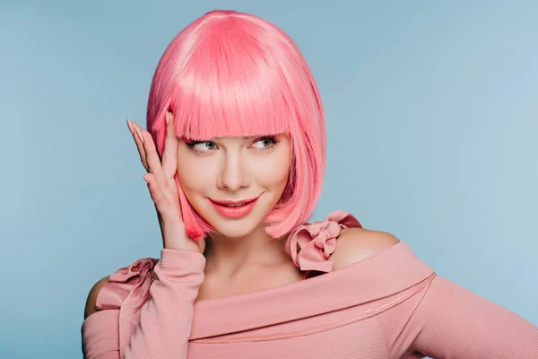 Chica de moda feliz gesto y posando en peluca rosa aislado en azul - foto de stock