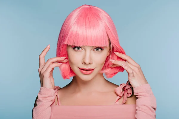 Attractive stylish girl gesturing and posing in pink wig isolated on blue — Stock Photo