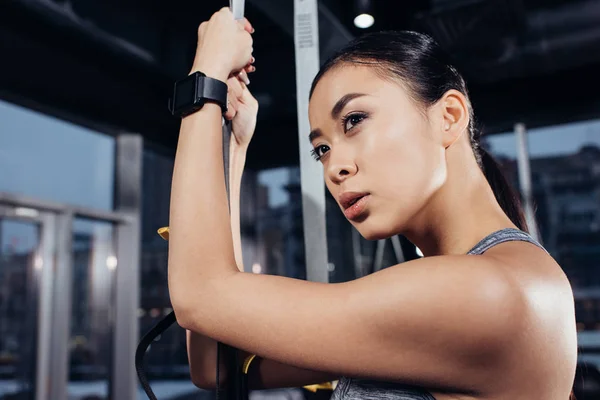 Крупним планом азіатська спортсменка з смугами опору в спортзалі — стокове фото