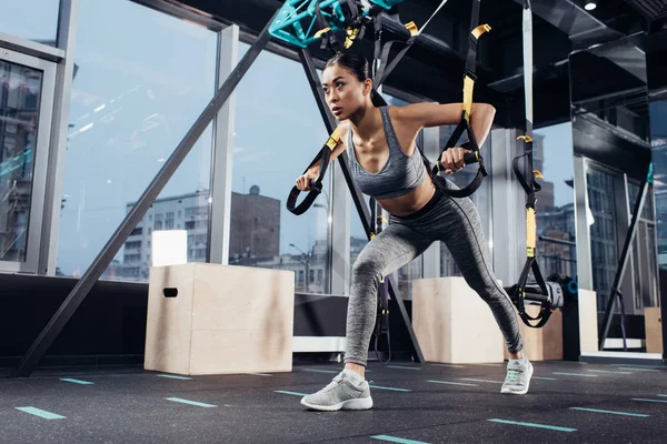 Приваблива азіатська дівчина в спортивному одязі тренування з смугами опору в спортивному центрі — стокове фото