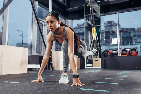 Slim asian girl stretching leg with resistance bands at gym — Stock Photo