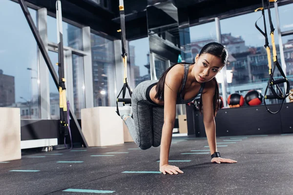 Athletische asiatische Sportlerin trainiert mit Widerstandsbändern im Sportzentrum — Stockfoto