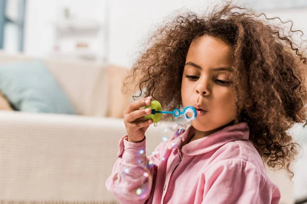 Africano americano niño soplando jabón burbujas - foto de stock