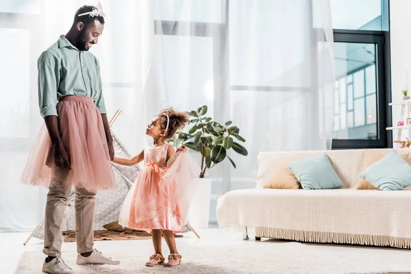 Felice padre afro-americano guardando la figlia carina in bel vestito — Foto stock