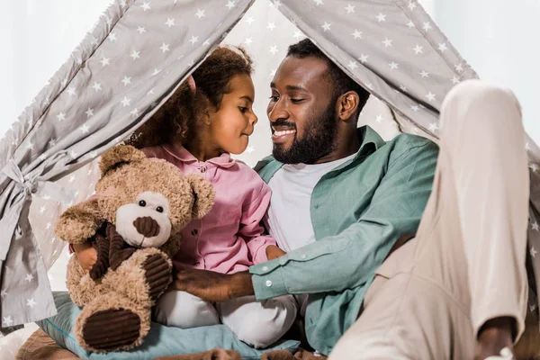 African american man looking at daughter in wigwam — Stock Photo