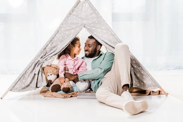 African american dad and daughter looking at each other in wigwam — Stock Photo