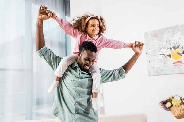 Afrikanisch-amerikanischer Mann spielt mit Tochter im Wohnzimmer — Stockfoto
