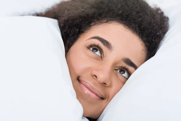 Close up vista da jovem mulher afro-americana deitada na cama — Fotografia de Stock