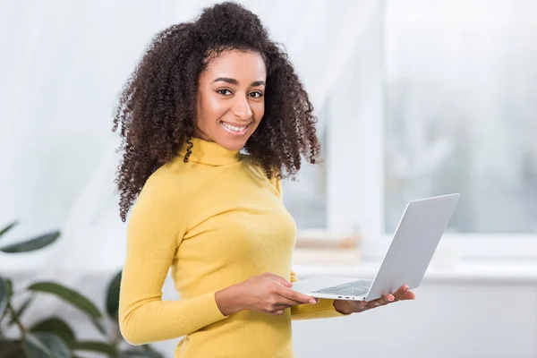 Sorrindo jovem freelancer do sexo feminino trabalhando no laptop em casa — Fotografia de Stock