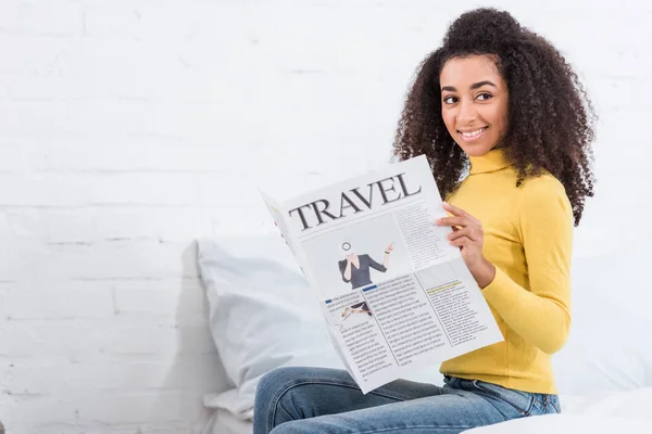 Encaracolado afro-americano menina lendo jornal de viagem em casa — Fotografia de Stock