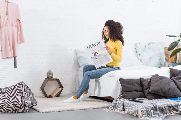 Счастливая африканская стильная американская девушка читает туристическую газету дома — стоковое фото