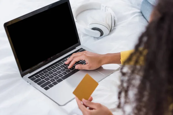 Teilbild einer Frau mit Kreditkarte und Online-Einkauf am Laptop im heimischen Bett — Stockfoto