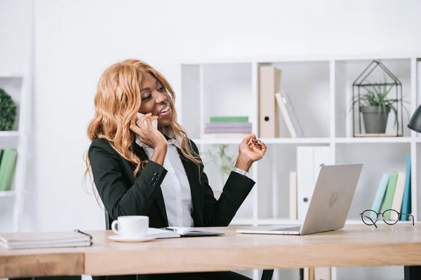 Joyeuse femme d'affaires afro-américaine parlant sur smartphone — Photo de stock