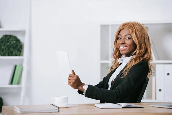 Allegra donna d'affari africana americana in possesso di tablet digitale in ufficio moderno — Foto stock