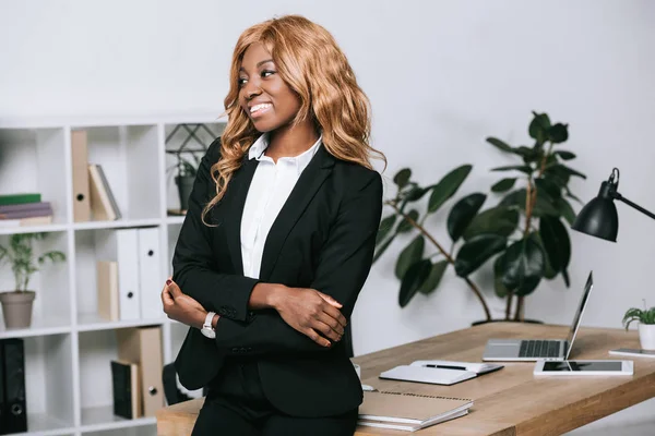Femme d'affaires afro-américaine aux bras croisés dans un bureau moderne — Photo de stock