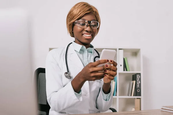 Schöne afrikanisch-amerikanische Wissenschaftlerin in Brille mit Smartphone — Stockfoto