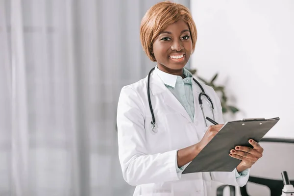 Усміхнений афроамериканський лікар зі стетоскопом і буфером — стокове фото