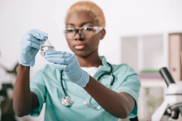 Attrayant scientifique afro-américain tenant fiole de laboratoire en laboratoire — Photo de stock