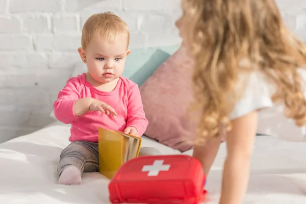 Selective focus of adorable kid holding book in children room — Stock Photo