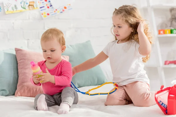 Adorable children playing with first aid kit in children room — Stock Photo