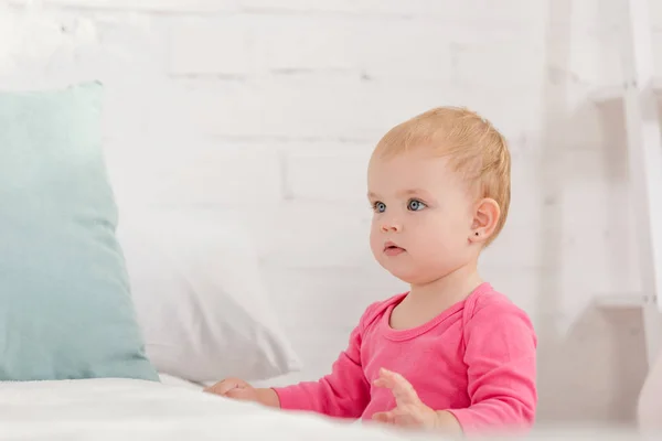 Entzückendes Kind lehnt sich ans Bett und schaut im Kinderzimmer weg — Stockfoto