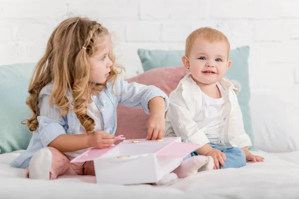 Fröhlich liebenswerte Schwestern spielen auf dem Bett im Kinderzimmer — Stockfoto