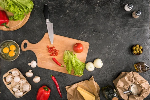 Vista superior de los ingredientes de la pizza y utensilios de cocina sobre fondo gris con espacio para copiar - foto de stock