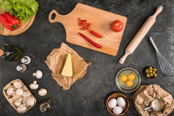 Vista superior de ingredientes de pizza e utensílios de cozinha em fundo cinza — Fotografia de Stock