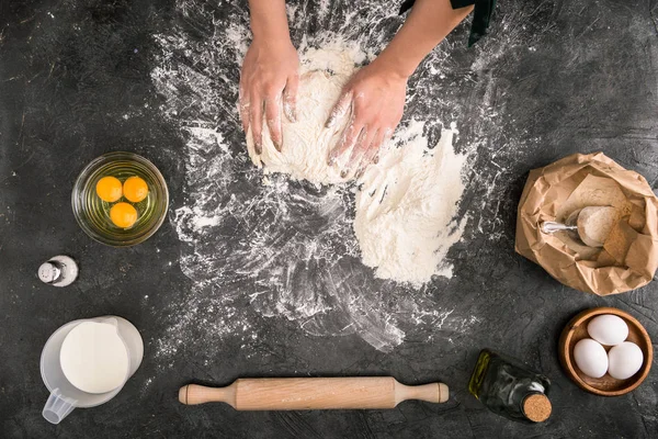 Teigansicht einer Frau, die Teig mit Zutaten auf grauem Hintergrund zubereitet — Stockfoto