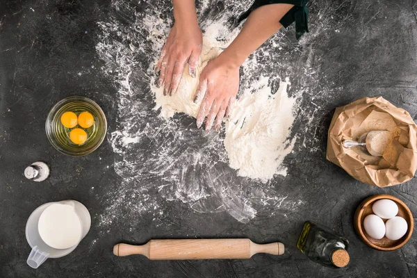 Vista cortada da mulher preparando massa com ingredientes em fundo cinza — Fotografia de Stock