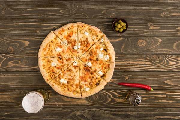 Top view of cheese pizza with ingredients on wooden table — Stock Photo