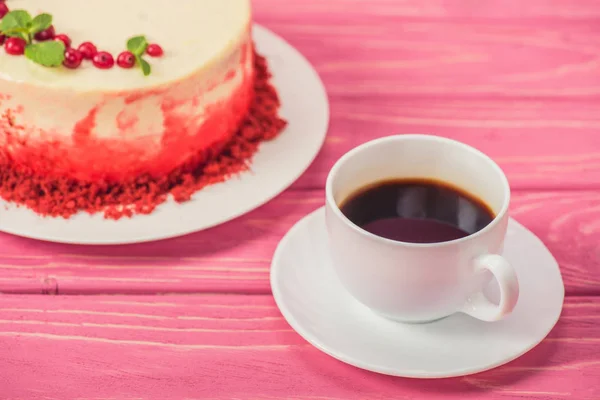Крупным планом торт украшен смородиной и мятой листья возле чашки кофе — стоковое фото