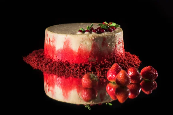 Білий торт, прикрашений червоною смородиною і листя м'яти біля полуниці ізольовані на чорному — стокове фото
