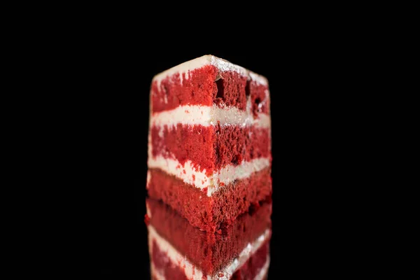 White and red piece of cream cake isolated on black — Stock Photo